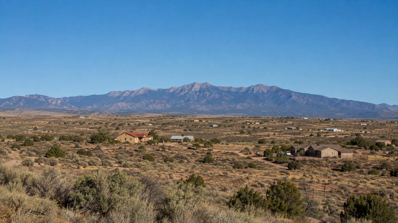 Open rural high-desert land near Los Lunas, New Mexico with the Manzano Mountains visible on the horizon